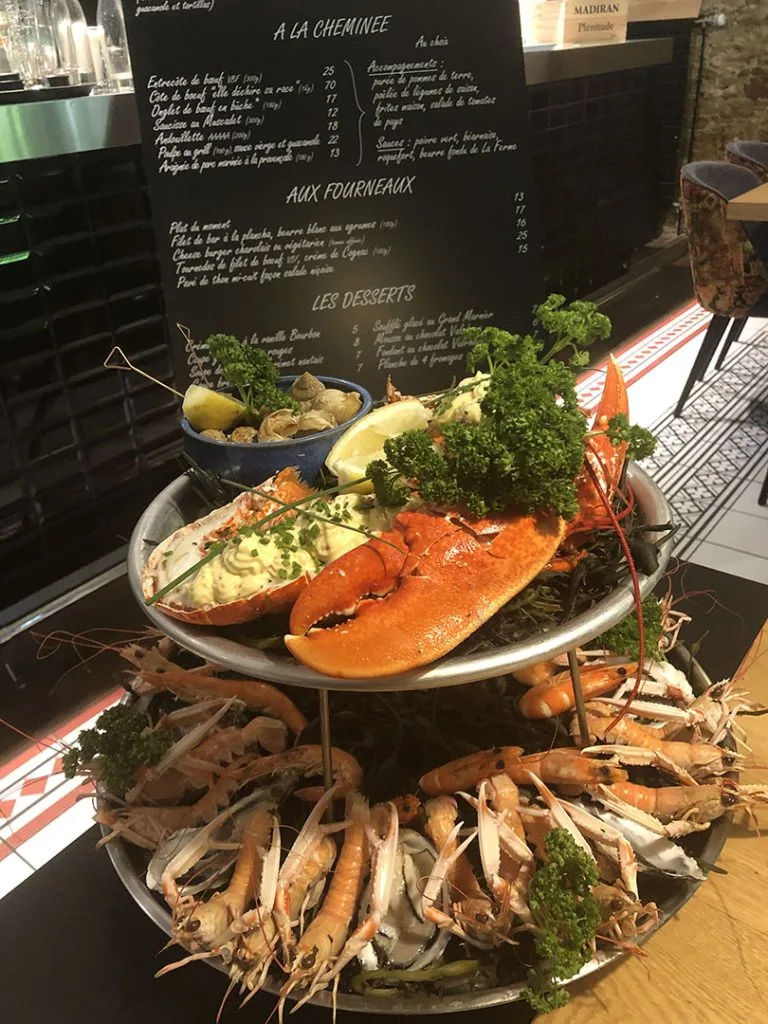 deux plateaux avec un homard, des bulots, des langoustines et des crevettes